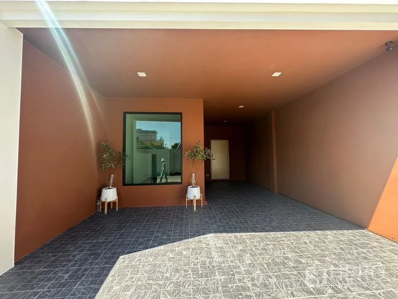 Home Office for rent in Wang Thonglang, Bangkok - Covered carport and entrance with terracotta walls, tiled floor, and potted plants.