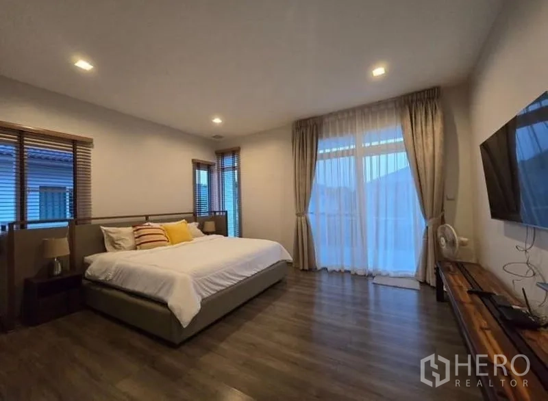 Detached House for rent - Spacious master bedroom with king bed, floor-to-ceiling curtains and wall-mounted TV.