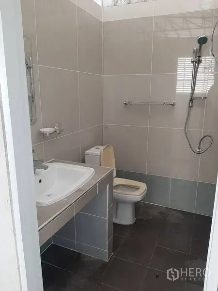 Warehouse for rent in Lam Luk Ka, Pathum Thani - Clean restroom with sink, toilet, and wall-mounted shower inside the property.