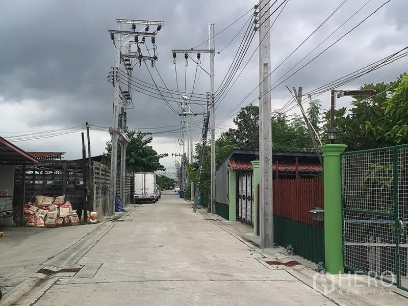 Warehouse for rent in Prawet, Bangkok - Access road to the warehouse with power lines, concrete pavement and a truck-friendly approach.