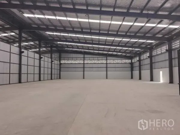 Factory for rent in Chon Buri - Open factory floor under insulated metal roof with skylights and steel columns.