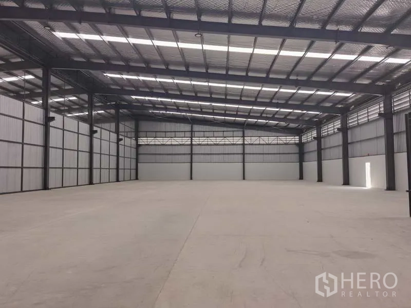 Factory for rent in Chon Buri - Open factory floor under insulated metal roof with skylights and steel columns.