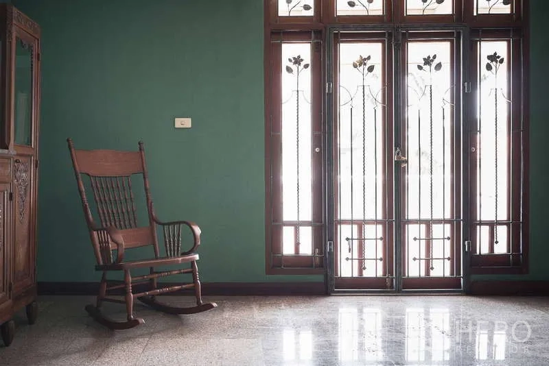 Townhouse for rent in Khlong Toei, Bangkok - Bright sitting area with rocking chair and tall glass doors