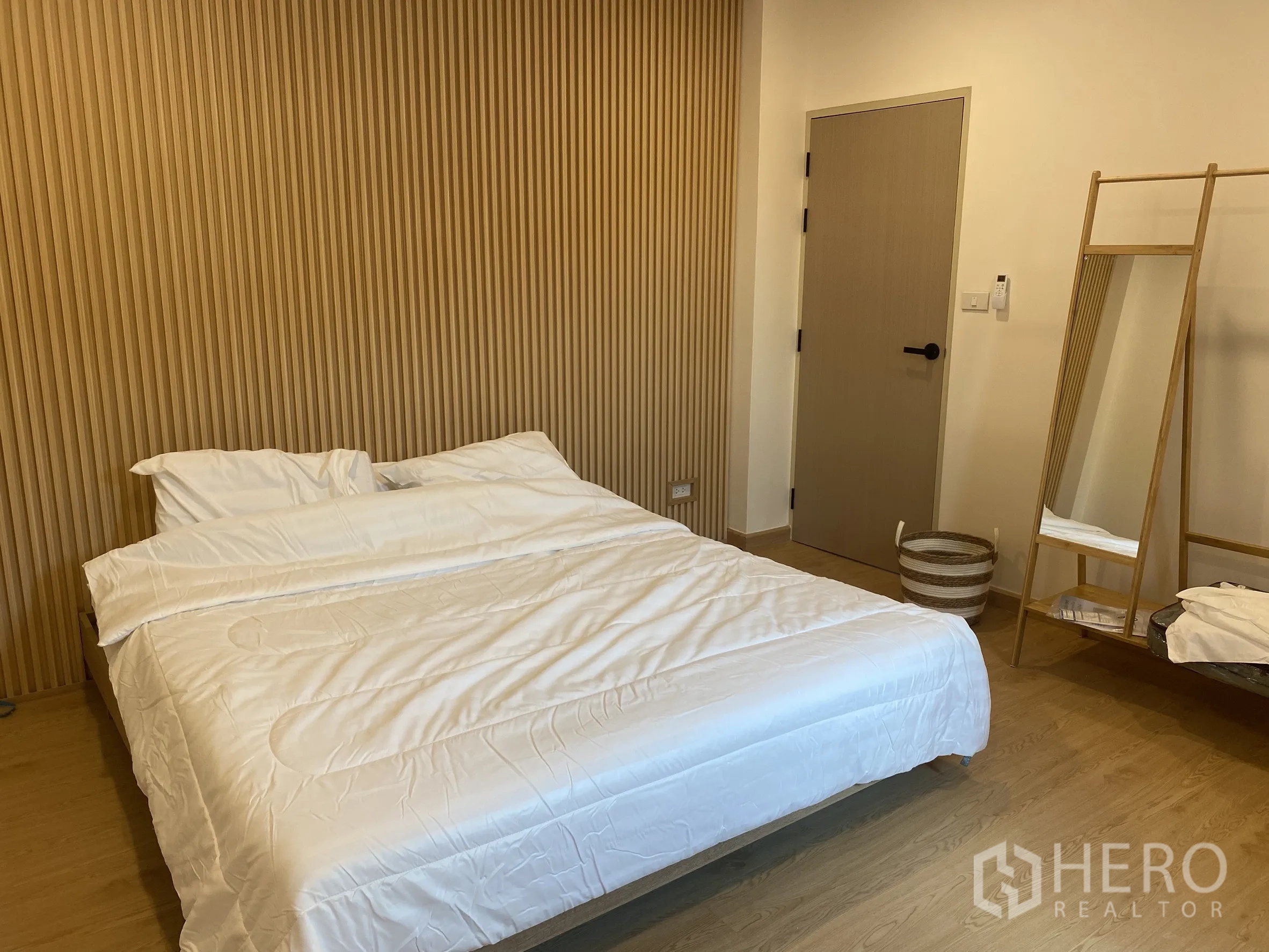 Detached House for sale in Suan Luang, Bangkok - Cozy bedroom with slat feature wall, freestanding mirror and wooden rack.
