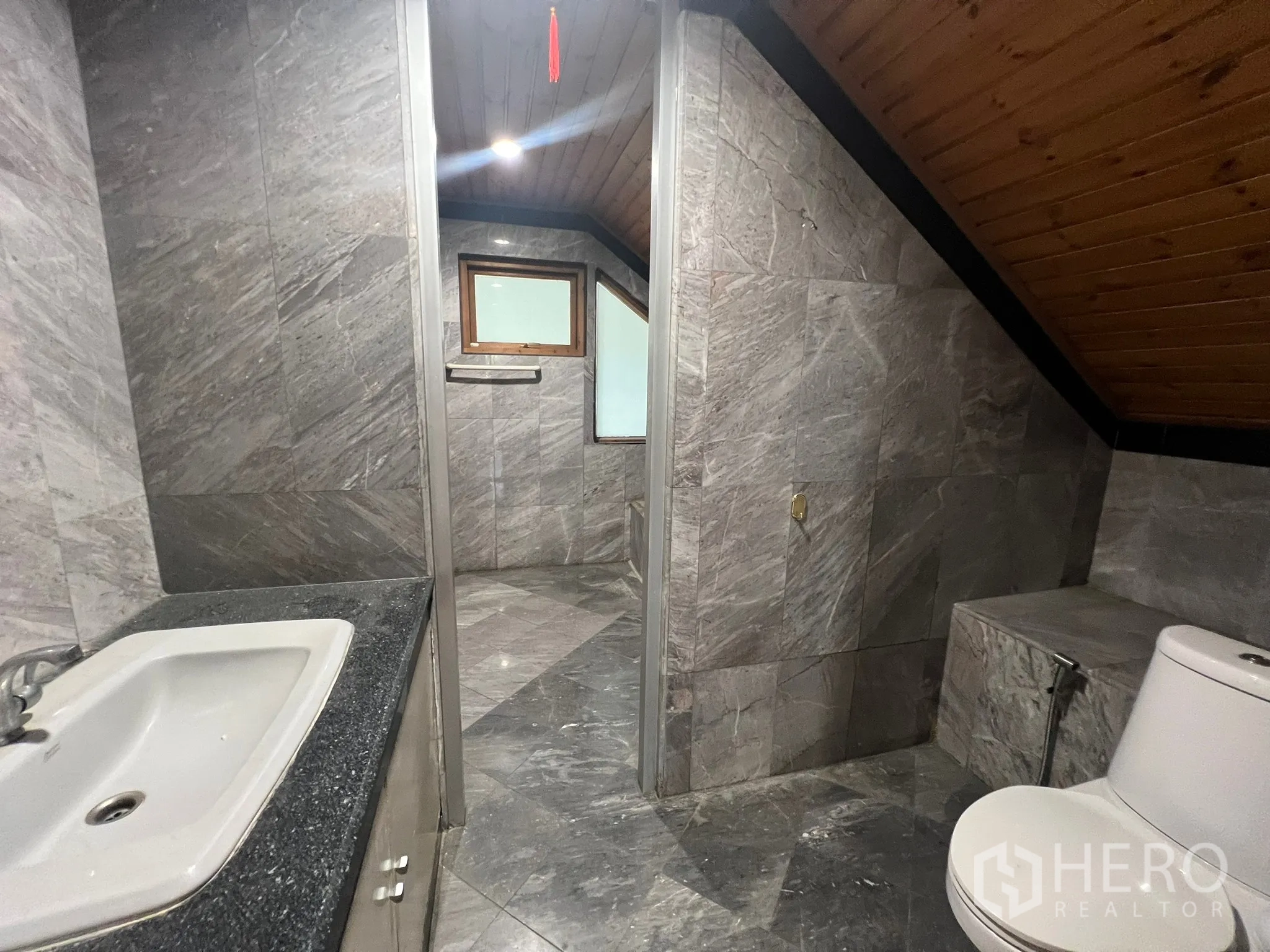 Home Office for rent in Suan Luang, Bangkok - Gray-tiled bathroom with sink, toilet and a separate shower area.