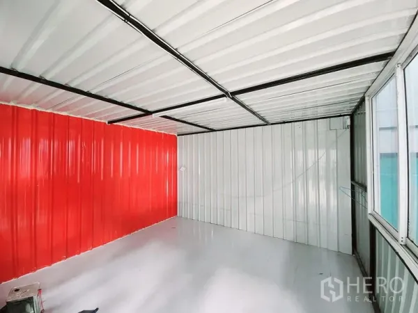 Warehouse for rent in Sam Phran, Nakhon Pathom - Compact internal office with metal wall panels, glossy white floor and a red feature wall.