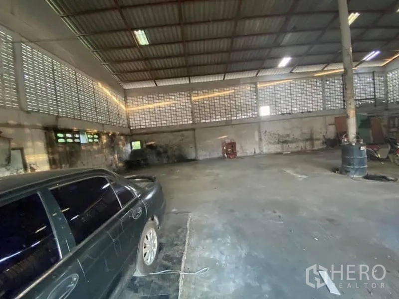 Factory for sale in Nong Chok, Bangkok - Industrial hall with concrete floor, car bay and high-roof lighting for operations.