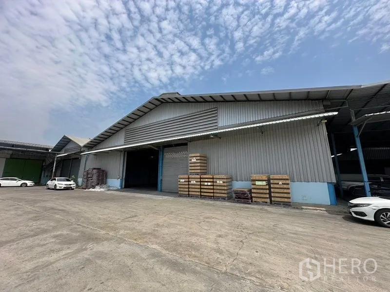 Warehouse for rent in Bang Pa-in, Phra Nakhon Si Ayutthaya - Warehouse facade with covered loading bay and stacked pallets in an open yard.