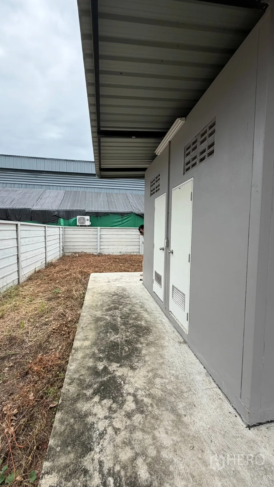 Factory for sale in Bang Len, Nakhon Pathom - Outdoor utility area with covered service rooms and concrete path.