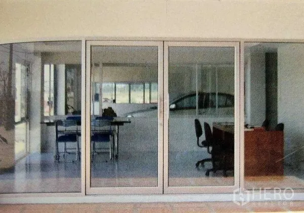 Factory for rent in Ban Phaeo, Samut Sakhon - Glass-partition office inside the factory with desks, chairs, and sliding doors overlooking the production space.