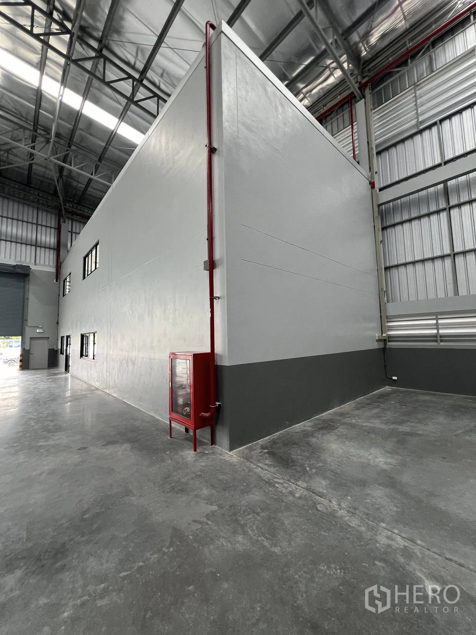 Warehouse for rent in Phra Pradaeng, Samut Prakan - Side of the office block inside the warehouse with a wall-mounted fire hose cabinet.