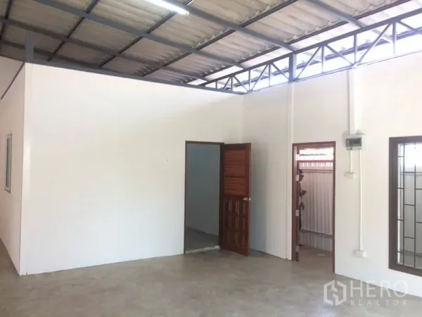 Warehouse for rent in Pathum Thani - Internal partitioned office area inside the warehouse with windows and doors beneath the steel roof structure.