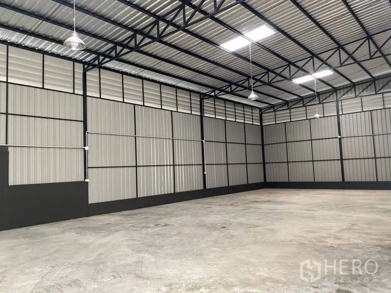 Warehouse for rent in Wang Thonglang, Bangkok - Column-free storage hall with metal cladding walls, pendant lights and a high ceiling.