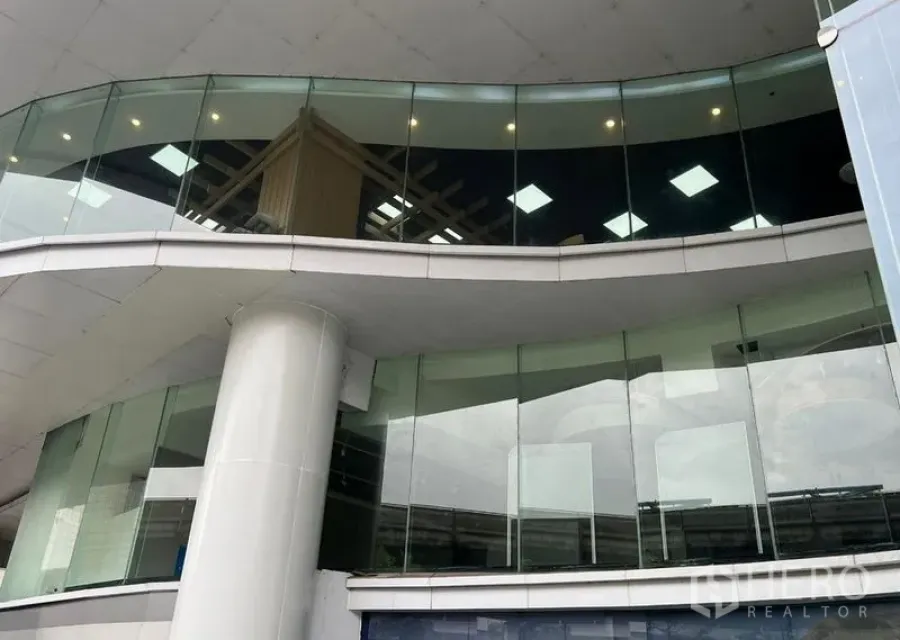 Retail Space for rent - Upper-level glass façade with canopy lighting and prominent corner frontage suitable for signage.