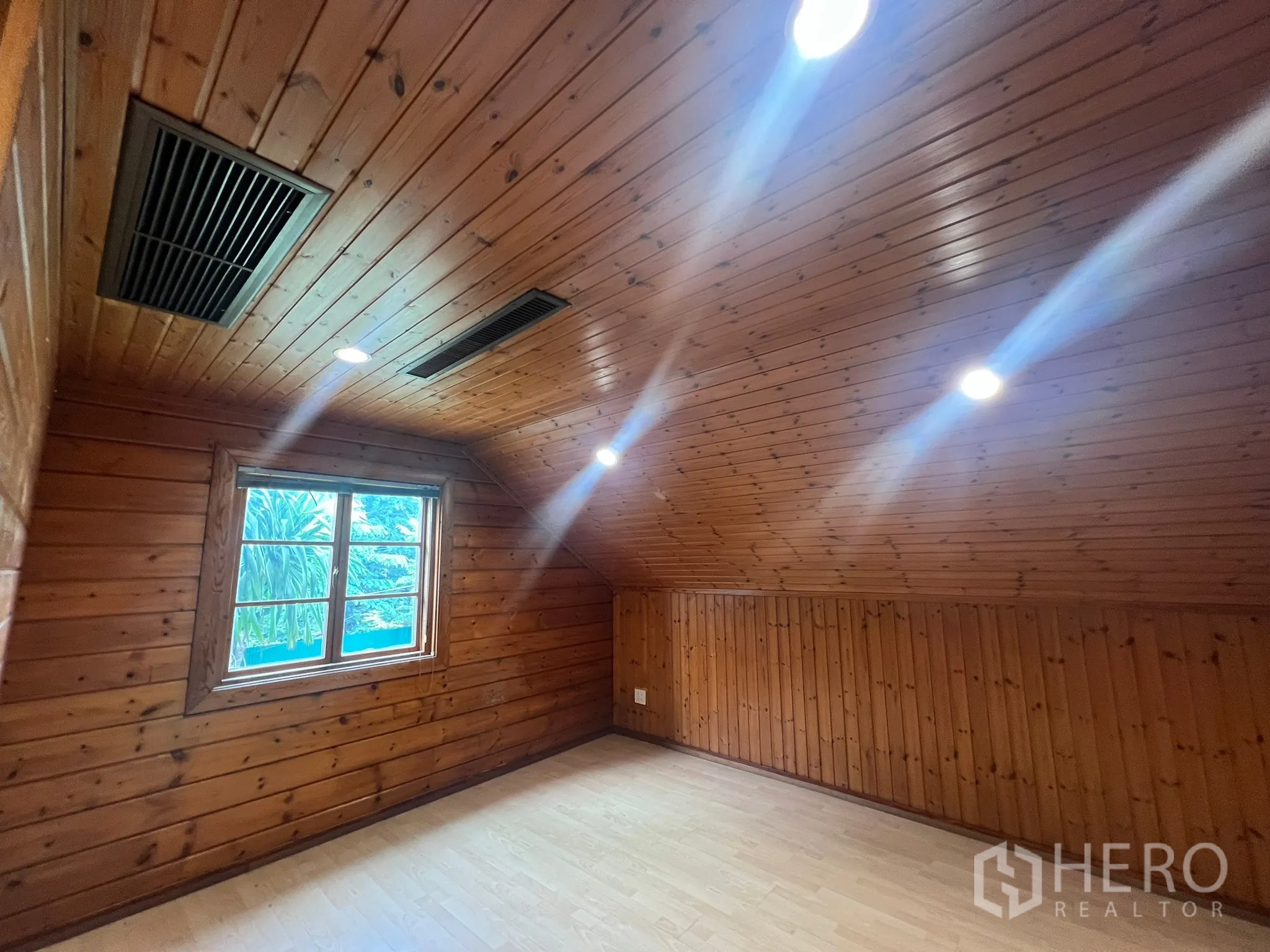 Home Office for rent in Suan Luang, Bangkok - Upper room with sloped wooden ceiling, window and ventilation grilles.