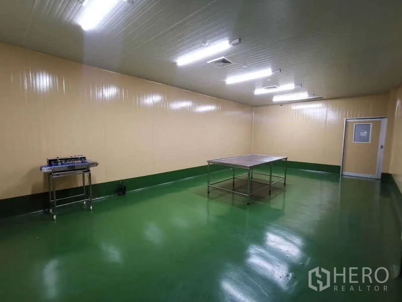 Warehouse for rent or sale in Mueang Samut Sakhon, Samut Sakhon - Spacious clean room with stainless work table under LED lighting.