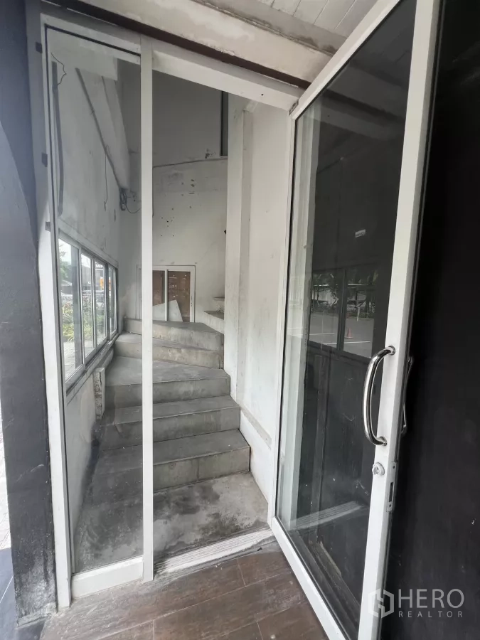 Retail Space for rent - Entrance vestibule with sliding glass door and staircase access.