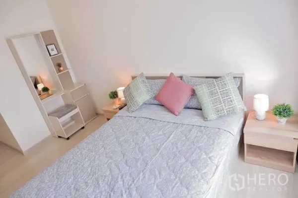 Condominium for rent in Huai Khwang, Bangkok - Cozy master bedroom with queen bed, side tables, and a built-in vanity in a Bangkok condominium.