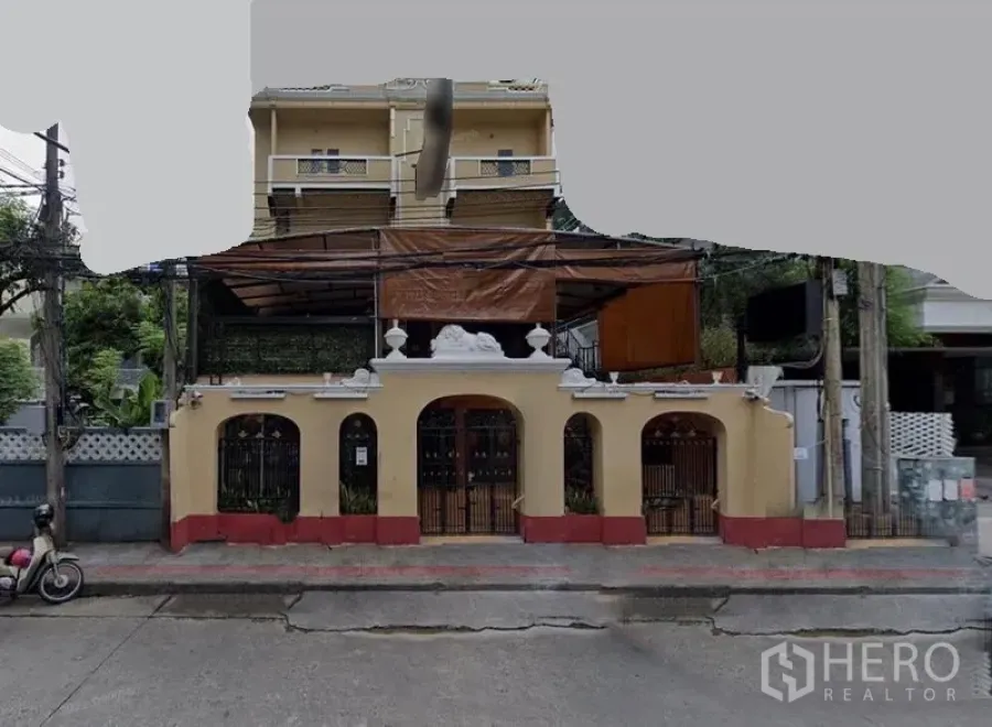 Shophouse for rent in Khlong Toei, Bangkok - Street-facing shophouse façade with arches, balcony and a covered terrace.