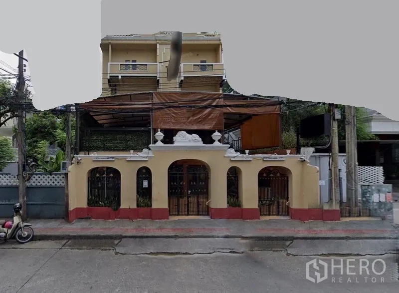 店屋 出租在Khlong Toei, Bangkok - 临街商铺楼立面，拱形门窗、阳台与遮蔽露台。
