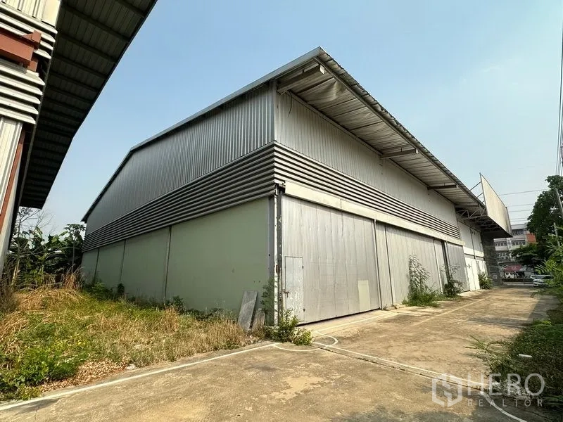 货栈 出租在Lam Luk Ka, Pathum Thani - 金属包板仓库后部外观，超大推拉门与装卸区。