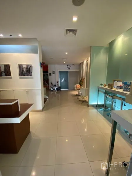 Home Office for rent in Wang Thonglang, Bangkok - Ground-floor reception hall with bar counter, stools and polished tile floor.