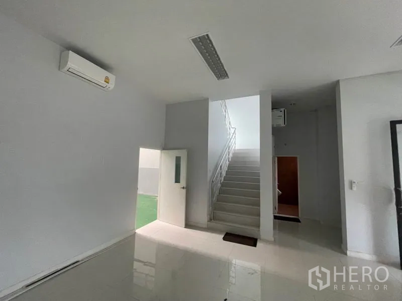Factory for rent in Lam Luk Ka, Pathum Thani - Ground-floor lobby with staircase and side door to service area.