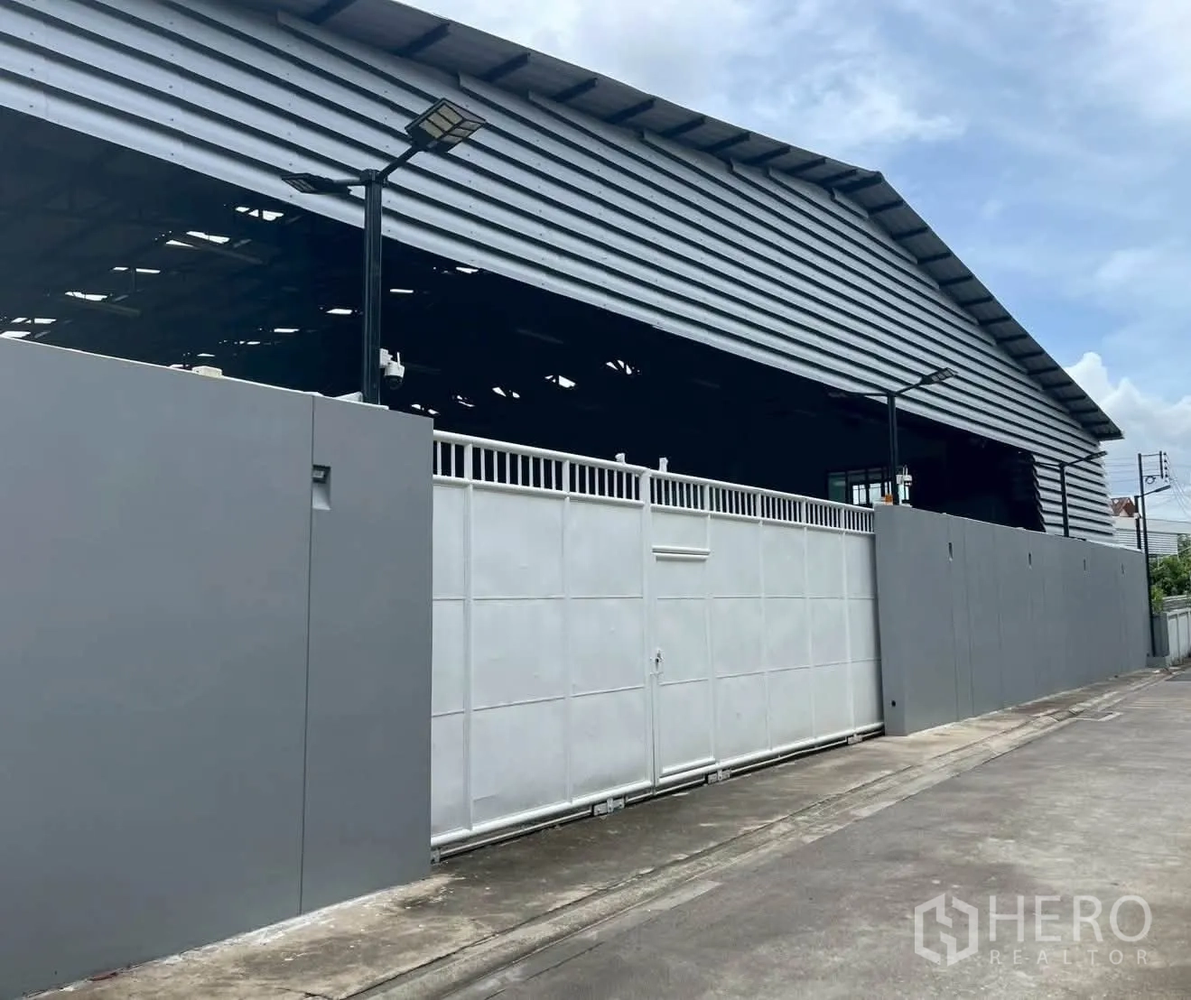 仓库 for rent in Taling Chan, Bangkok - 临街视角的仓库，设高围墙、推拉大门与室外照明。