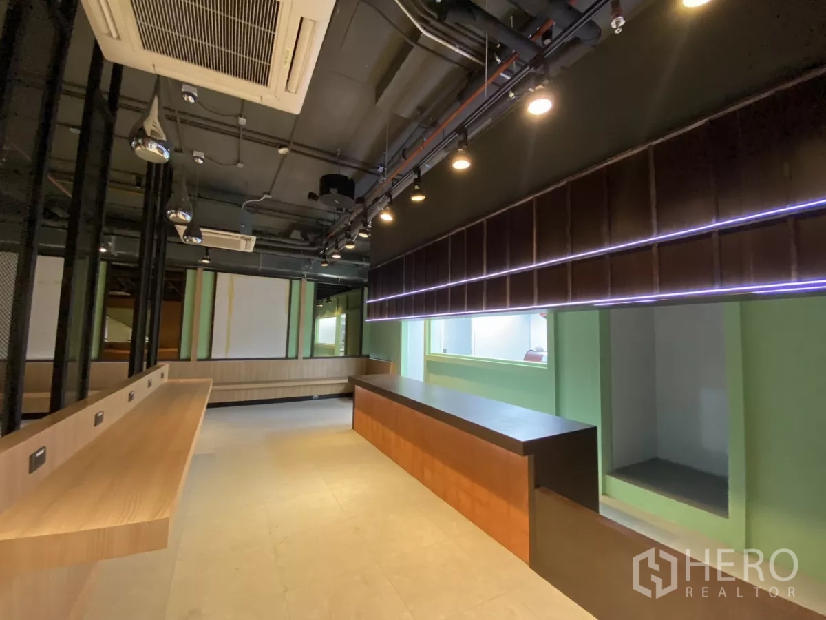 Retail Space for rent - Long service counter with accent strip lighting and green feature walls.