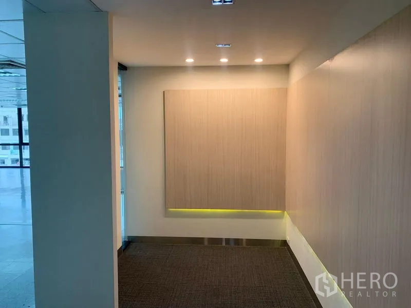 Office Space for rent in Bang Rak, Bangkok - Reception corner with wood feature panel and ceiling spotlights.