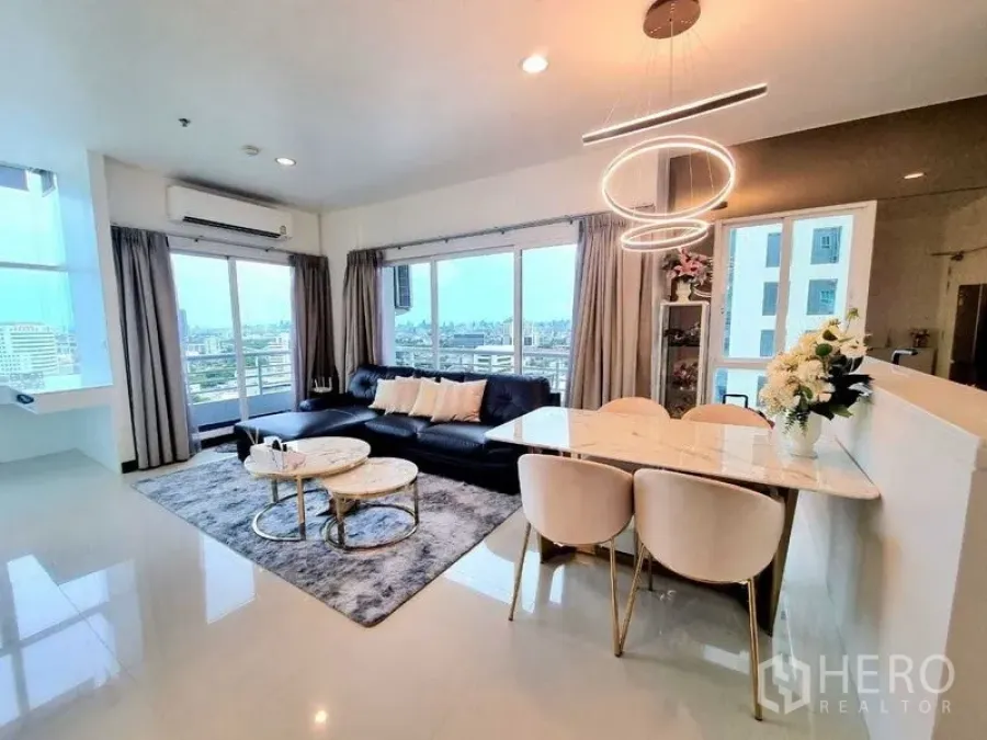 Condominium for sale - Sunlit living room combining lounge and dining areas, large curtains and balcony access with skyline.