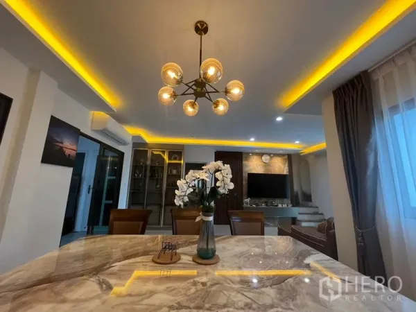 Townhouse for rent - Dining area with marble table and contemporary chandelier beside full-height curtains.