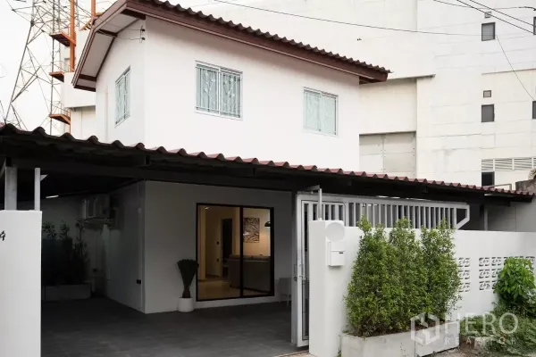Detached House for rent in Huai Khwang, Bangkok - Two-storey detached house exterior with gated entrance and covered carport in Huai Khwang.