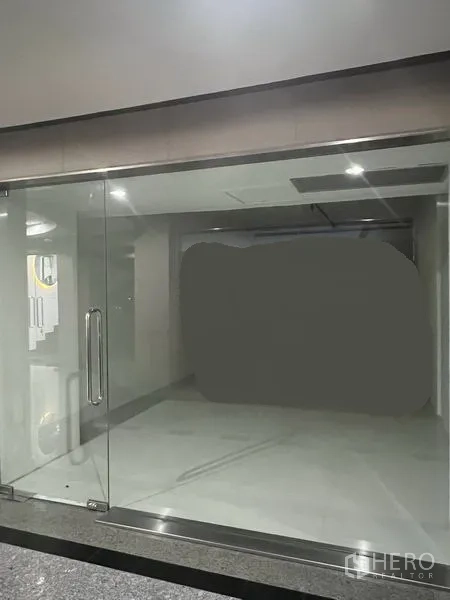 Retail Space for rent in Khlong Toei, Bangkok - Empty 31 sqm retail unit with full-height glass frontage, double glass doors, bright tiled interior and recessed ceiling lights near BTS Thong Lo.