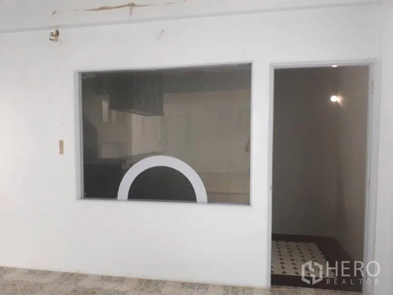 Detached House for rent in Watthana, Bangkok - White-walled room featuring an interior picture window and a doorway to a side room.