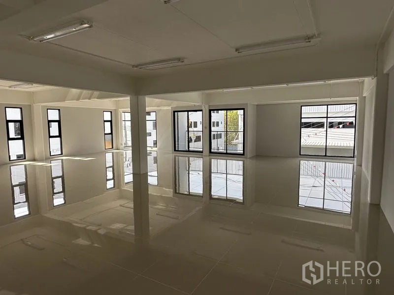 Warehouse for rent in Bang Phli, Samut Prakan - Sunlit upper-floor office space with large windows and glossy tile flooring.