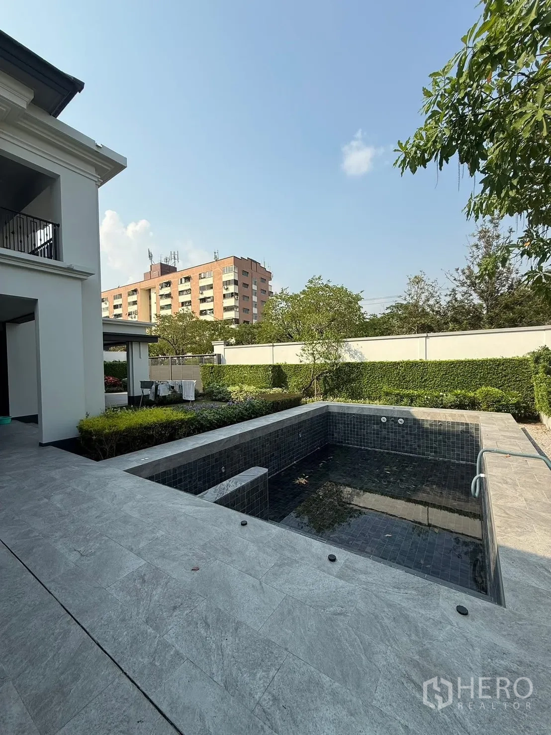 Detached House for rent in Bang Kapi, Bangkok - Private outdoor terrace with dark-tiled swimming pool, landscaped hedges and high privacy walls.