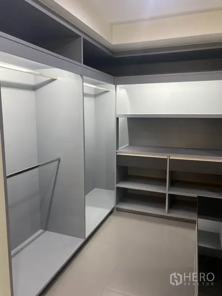 Condominium for rent in Khlong Toei, Bangkok - Spacious walk-in closet with open hanging rails and multiple shelves.