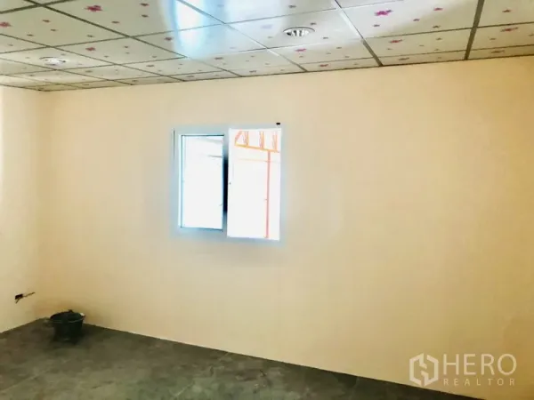 Warehouse for rent in Bang Kapi, Bangkok - Simple office room inside the warehouse with a small window, drop ceiling, and concrete floor.