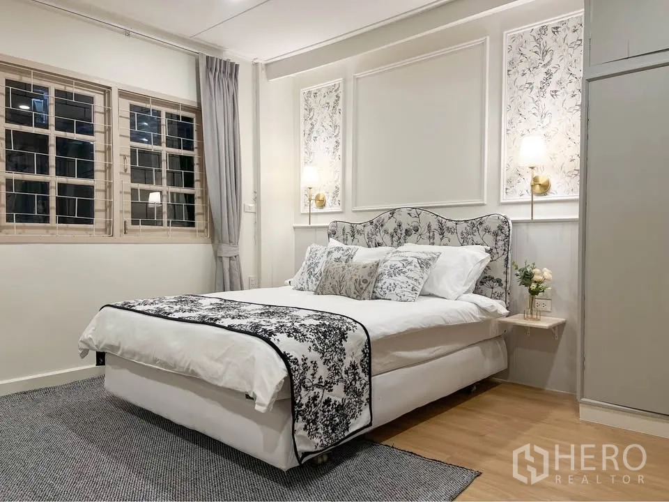 Detached House for rent in Huai Khwang, Bangkok - Second bedroom with large windows, feature paneling and a queen bed.