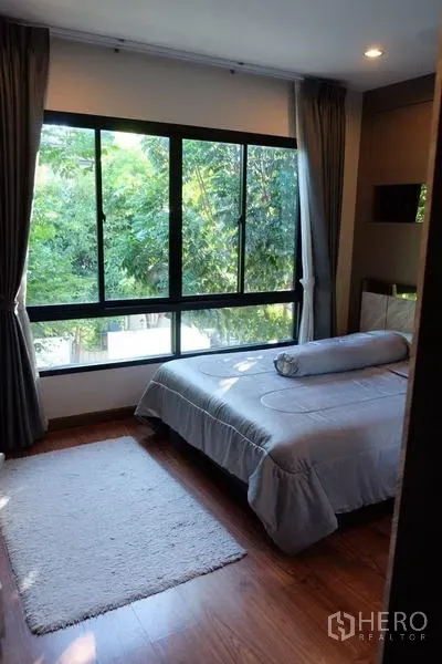 Detached House for rent in Bang Phli, Samut Prakan - Bright bedroom with large corner windows overlooking green trees.