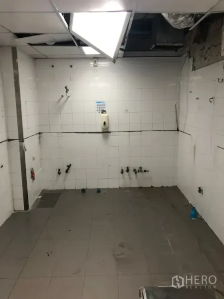 Retail Space for rent in Khlong Toei, Bangkok - Tiled kitchen room with plumbing points and bright lighting ready for fit-out.