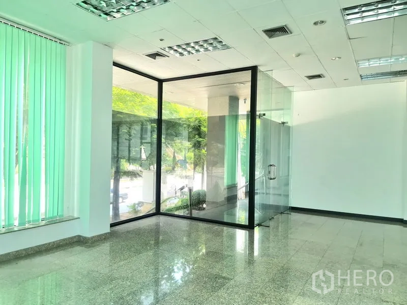 Retail Space for rent in Sathon, Bangkok - Retail corner featuring a floor-to-ceiling glass box room and greenery visible outside the window.