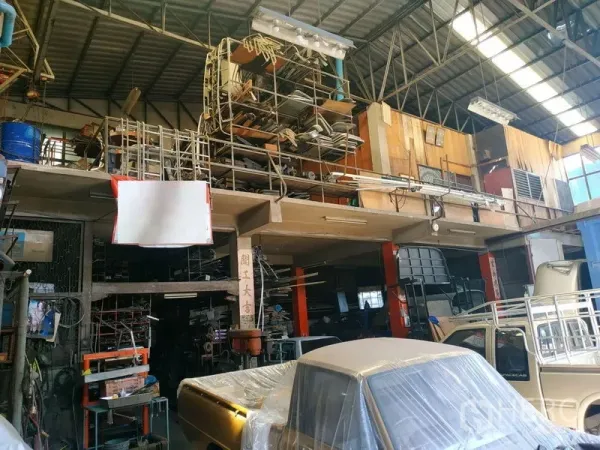Warehouse for rent in Yan Nawa, Bangkok - Open-plan workshop area with elevated shelving, industrial lighting and vehicle bays inside the warehouse.