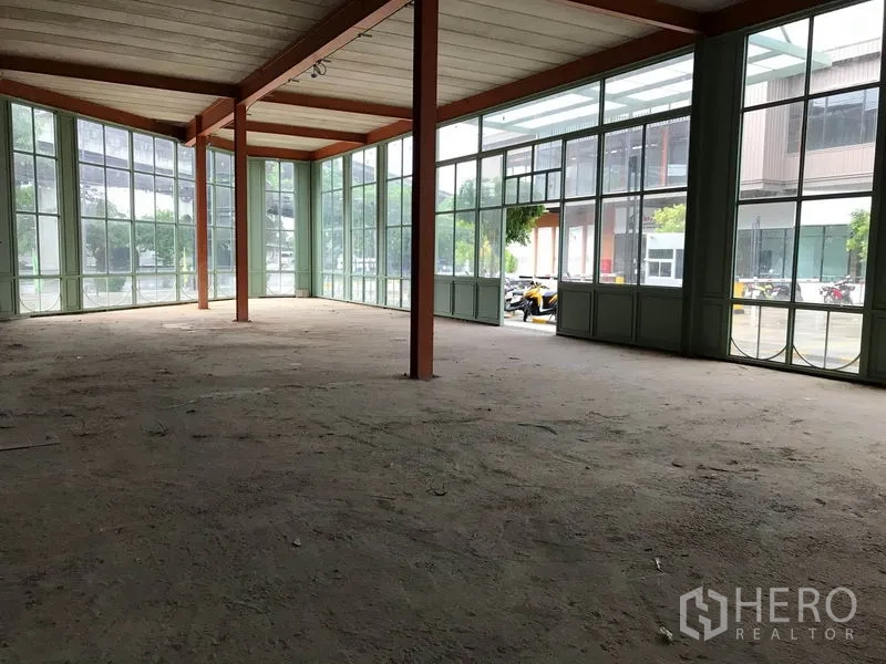 Retail Space for rent in Bang Na, Bangkok - Bright corner retail showroom with wraparound glass walls and exposed steel beams.