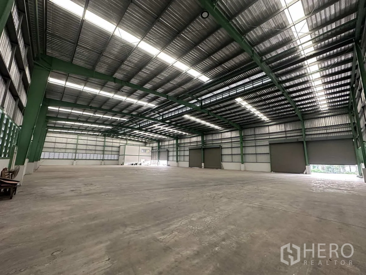 工厂 出租在Mueang Samut Prakan, Samut Prakan - 生产区展示三樘大型卷门、钢梁结构与自然采光。