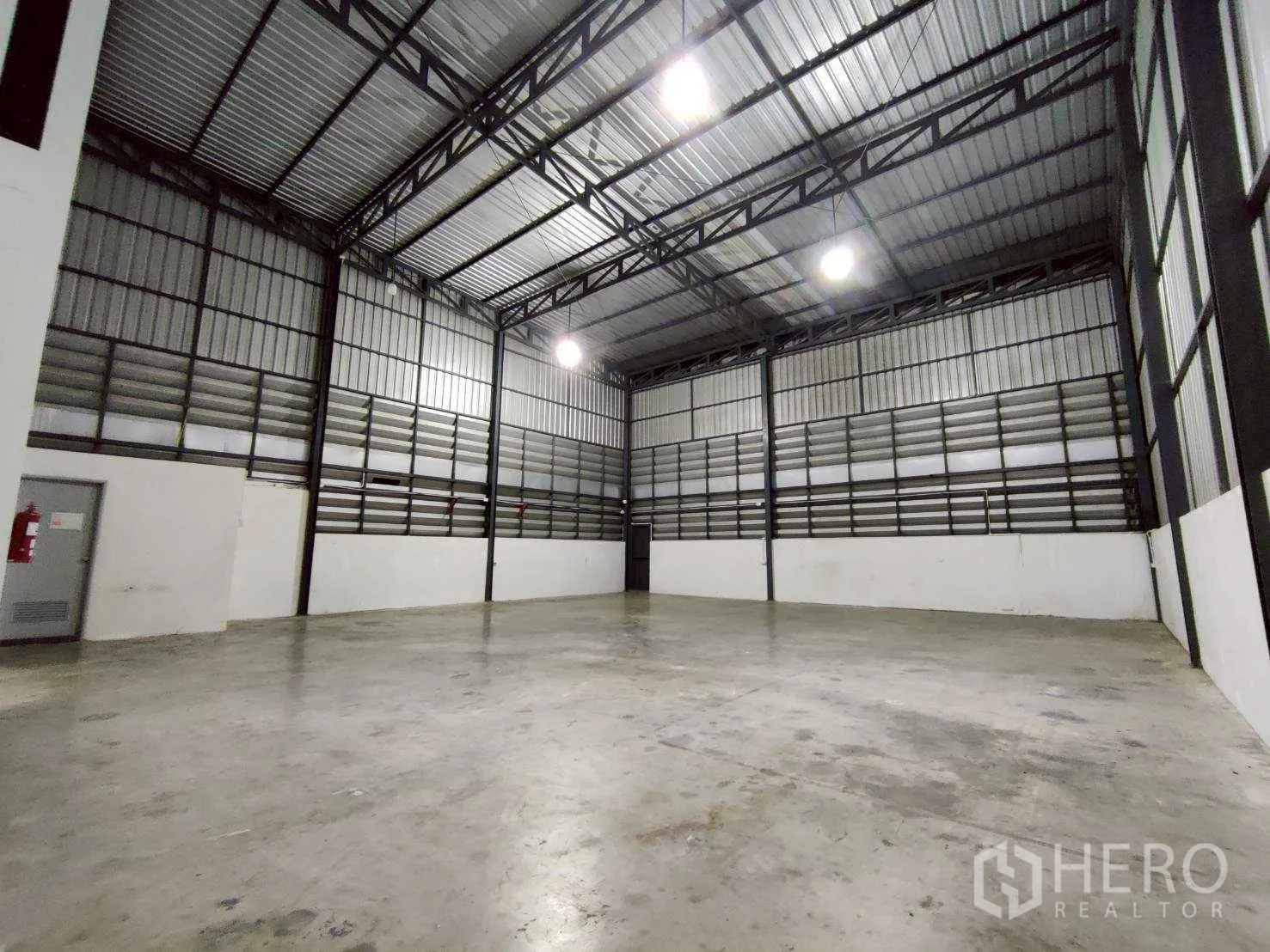 仓库 for rent in Lam Luk Ka, Pathum Thani - 空旷仓库地面，金属夹层墙面与顶置照明。