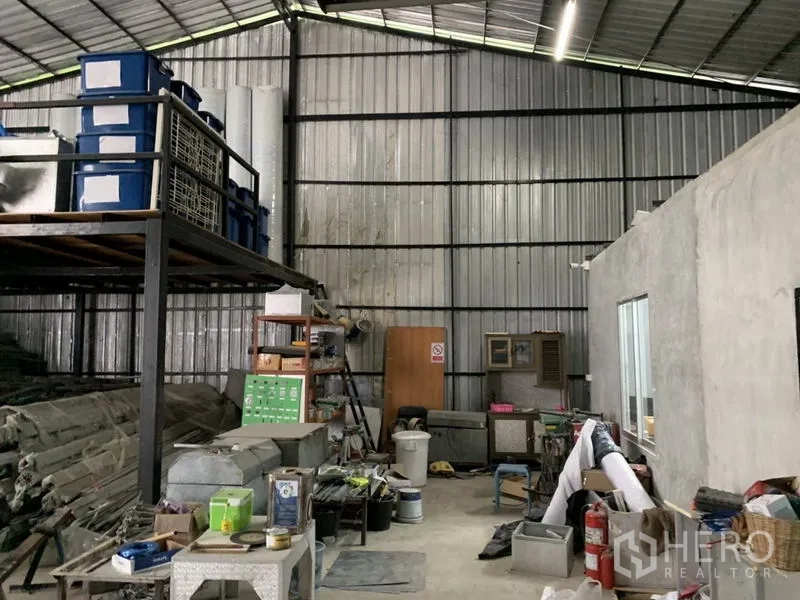 Warehouse for rent in Bang Kapi, Bangkok - Industrial storage zone with tall metal walls, shelving, equipment and LED lighting.