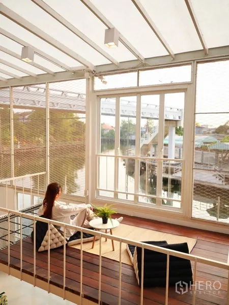 Townhouse for rent in Khlong Toei, Bangkok - Enclosed terrace lounge with panoramic canal view and glass walls in a townhouse near BTS On Nut.