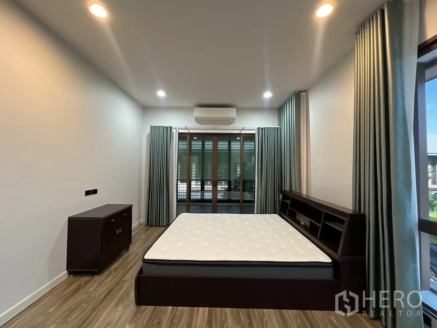 Detached House for rent or sale in Bang Kapi, Bangkok - Primary bedroom with bed frame, air conditioner and balcony doors